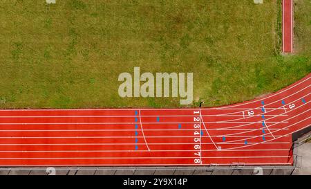 Immagine aerea di una nuova pista da corsa rossa con linee di corsia bianche e altre marcature. Foto Stock