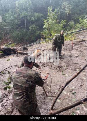 Contea di Polk, Stati Uniti. 26 settembre 2024. I soldati dell'esercito degli Stati Uniti della 130th Maneuver Enhancement Brigade, camminano oltre una frana di fango durante le operazioni di ricerca e salvataggio a seguito di inondazioni record dall'uragano Helene, il 26 settembre 2024 nella contea di Polk, Carolina del Nord. Crediti: Sergente Jordan Hayden/US Army Photo/Alamy Live News Foto Stock