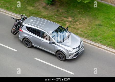 OSTRAVA, CECHIA - 28 MAGGIO 2024: SUV Toyota RAV4 grigio con portabiciclette, effetto di sfocatura del movimento Foto Stock