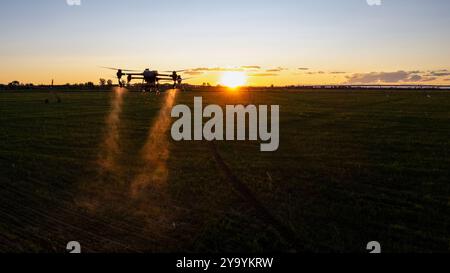 Il drone agro lavora sul campo. Trattamento sul campo con sostanze chimiche. Irrorazione di pesticidi contro i parassiti. Innovazioni nel settore agricolo. Nuovo Technolo Foto Stock