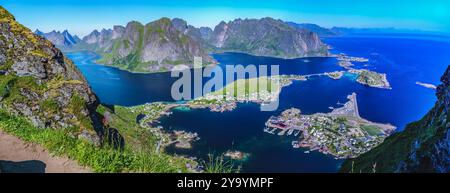 Vista panoramica mozzafiato dei fiordi norvegesi con scogliere ripide e un pittoresco villaggio costiero sottostante, circondato da acque cristalline. Foto Stock