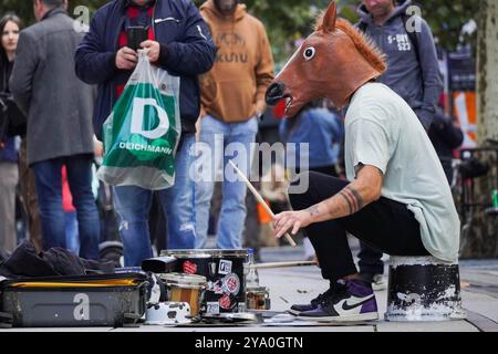 Francoforte, Assia, Germania. 11 ottobre 2024. Un uomo che indossa una maschera da cavallo suona un kit di tamburi improvvisato in una strada a Francoforte, in Germania. (Immagine di credito: © Matias Basualdo/ZUMA Press Wire) SOLO PER USO EDITORIALE! Non per USO commerciale! Foto Stock