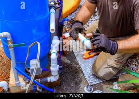 L'idraulico sta assemblando il servizio di collegamento tra il sistema di acqua dei pozzi all'interno dell'azienda. Foto Stock