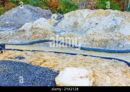 Preparazione della base di terra alla cassaforma di installazione per il versamento di calcestruzzo in cantieri edili Foto Stock