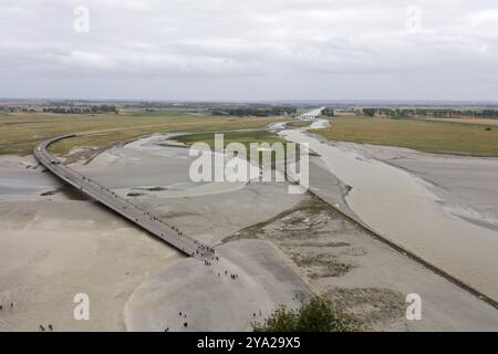 Ampio paesaggio fluviale con ponte e gente a pochi passi, le Mont-Saint-Michel Foto Stock