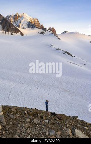 Paesaggio di alta montagna al tramonto, Glacier du Tour, fotografo con fotocamera di fronte al ghiacciaio e alla vetta della montagna alla luce della sera, in cima Foto Stock