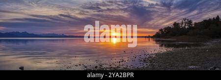 Panorama di un lago al tramonto con spettacolari nuvole e colori luminosi, Chiemsee Foto Stock