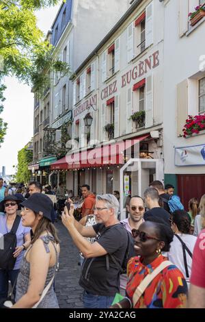 Vivace scena di strada con persone che scattano foto di fronte ai ristoranti di Parigi Foto Stock