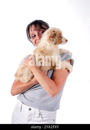 donna e pastore australiano davanti a sfondo bianco Foto Stock