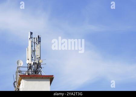Ronda, malaga, spagna, torre di telecomunicazioni 5g sul tetto di un edificio con un cielo blu con nuvole bianche Foto Stock