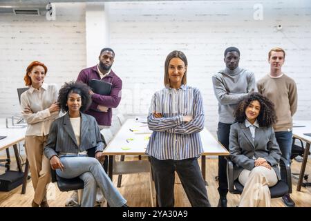 Donna d'affari caucasica sicura di sé, orgogliosa di essere accanto ai colleghi in un coworking Foto Stock