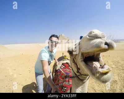 Selfie con cammello sorridente alle piramidi. Il Cairo in Egitto Foto Stock