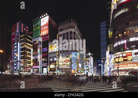 Shinjuku, Giappone, 18 maggio 2019: Cartelli al neon illuminano il trafficato quartiere Shinjuku di notte lungo Yasukuni-dori Avenue con folle di persone, Asia Foto Stock