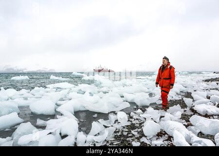 L'uomo cammina attraverso il ghiaccio e la neve in Antartide. Iceberg e tutto il resto congelato intorno a te. Freddo Foto Stock