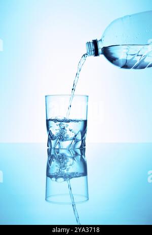 Il bicchiere d'acqua viene riempito con acqua proveniente da una bottiglia Foto Stock