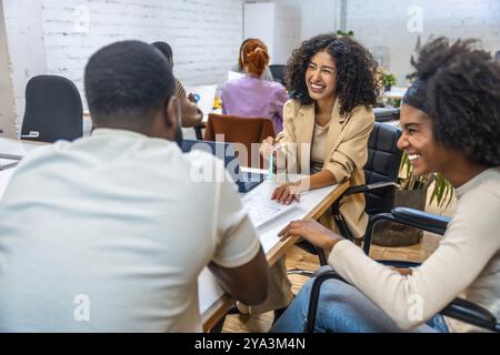 Tanti colleghi felici e diversi che parlano e ridono in una sala riunioni Foto Stock