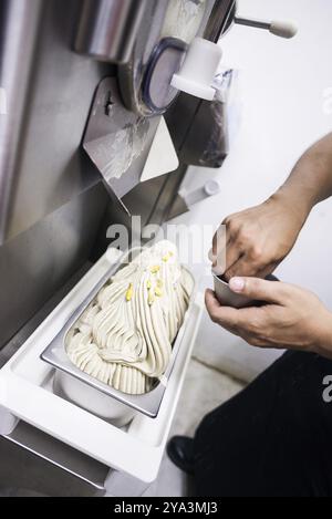 Preparare gelatto italiano in cucina con la macchina per il gelato Foto Stock