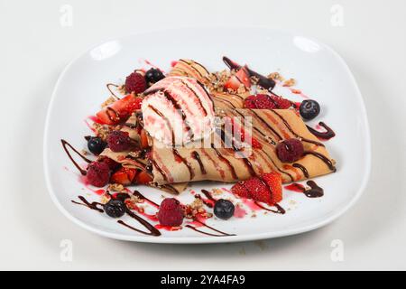 Crepes con frutti di bosco freschi, salsa al cioccolato e gelato Foto Stock