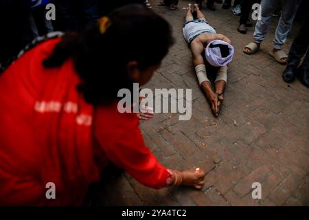 Bhaktapur, Nepal. 12 ottobre 2024. Un devoto rotola a terra mentre esegue rituali religiosi di fronte al tempio Brahmayani durante Durga Puja, il giorno più propizio del festival Dashain, a Bhaktapur. Credito: SOPA Images Limited/Alamy Live News Foto Stock