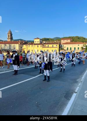 Pontremoli in Toscana, banda in marcia che suona per le strade con edifici Pontremoli sullo sfondo. Foto Stock