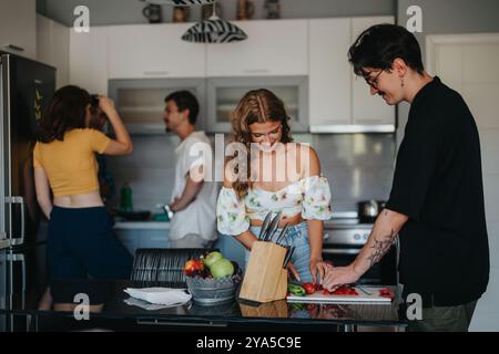 Amici che si godono una sessione di cucina informale in cucina Foto Stock