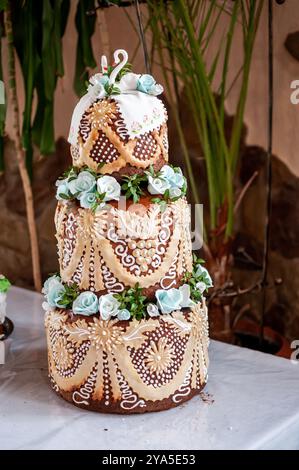 Elegante torta a tre livelli decorata con decorazioni floreali. Foto Stock