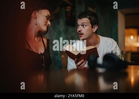 Uomo che legge un libro a una donna in un ambiente accogliente Foto Stock