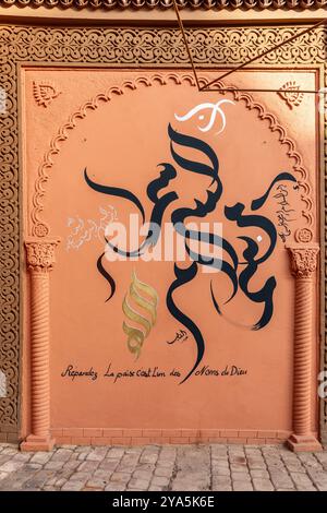 Nella medina di Marrakech, un'iscrizione sul muro riproduce una surah del Corano: "Diffondi la pace, è uno dei nomi di Dio" Foto Stock