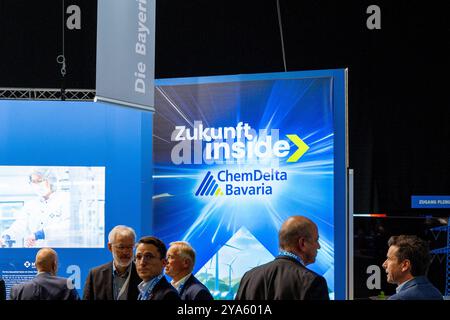 Augusta, Baviera, Germania - 12 ottobre 2024: Stand ChemDelta Bavaria alla conferenza del partito CSU, presentato con il motto: Future Inside. Lo stand è stato progettato con grafiche blu e gialle che simboleggiano le tecnologie moderne e l'industria chimica *** Messestand von ChemDelta Bavaria auf dem CSU-Parteitag, präsentiert unter dem motto: Zukunft Inside. Der Stand ist mit blauen und gelben Grafiken gestaltet, die moderne Technologien und die chemische industrie symbolisieren Foto Stock