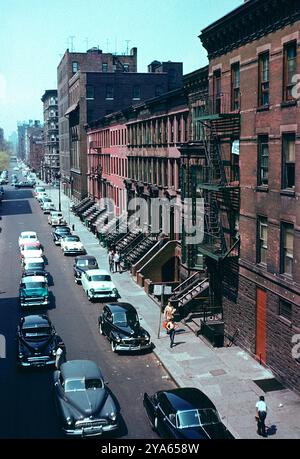 Manhattan New York Street USA anni '1950 Brownstone ospita i bambini che giocano a baseball sulle auto retro America del marciapiede Foto Stock