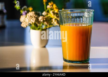 Succo di frutta al tavolo della colazione alla luce del sole Foto Stock