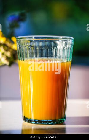 Succo di frutta al tavolo della colazione alla luce del sole Foto Stock