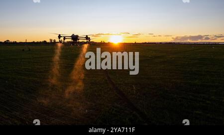 Il drone agro lavora sul campo. Trattamento sul campo con sostanze chimiche. Irrorazione di pesticidi contro i parassiti. Innovazioni nel settore agricolo. Nuovo Technolo Foto Stock