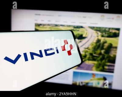 In questa immagine, un telefono cellulare con il logo della società francese Vinci S.A. è visibile di fronte al sito Web aziendale. Foto Stock