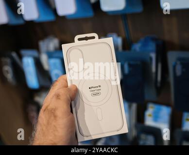 Parigi, Francia - 20 settembre 2024: POV di una mano maschile che tiene in mano i computer Apple più recenti custodia trasparente per iPhone 16 con compatibilità MagSafe per la ricarica wireless. Foto Stock