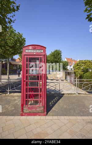 Storica cabina telefonica rossa sul lungomare di Milau con il fiume Salze a Bad Salzuflen, Lippe District, Renania settentrionale-Vestfalia, Germania, Europa Foto Stock