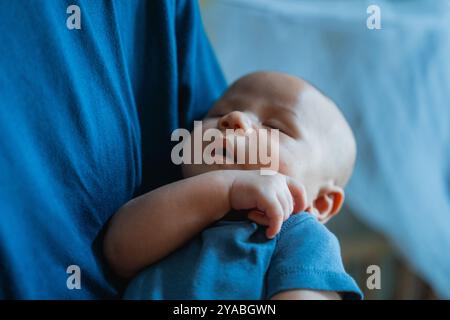Un dolce bambino addormentato in Fathers Loving Arms Un momento emozionante Foto Stock