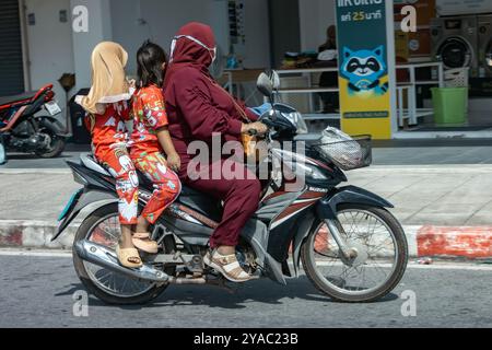 YALA, THAILANDIA, Mar 01 2024, Una donna con ragazze in abbigliamento tradizionale cavalcano insieme su una moto Foto Stock