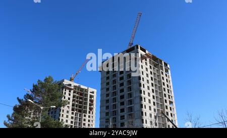 alti edifici residenziali in costruzione, costruzione di alti edifici con gru Foto Stock