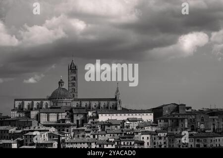 Paesaggio urbano di Siena con la Cattedrale o la Chiesa del Duomo di Siena e il suggestivo cielo Foto Stock