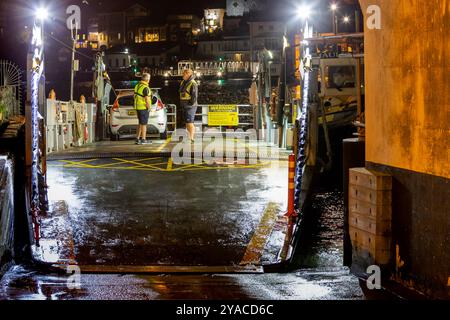 Vista notturna dettagliata del traghetto inferiore di Dartmouth e dell'equipaggio in attesa allo scivolo per lasciare Dartmouth con il fiume, il lungomare e il Kingswear. Foto Stock