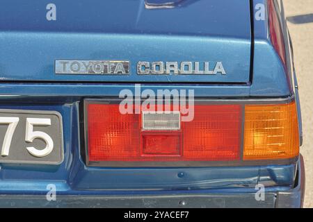 Primo piano dell'estremità posteriore di una corolla toyota blu, che mette in risalto il suo design classico e il logo iconico Foto Stock