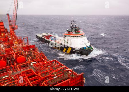 Nave di approvvigionamento accanto a un FPSO per il petrolio e il gas nel mare del nord Foto Stock