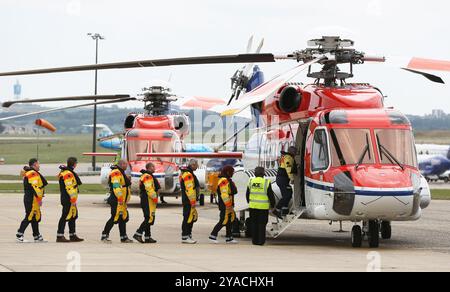 I lavoratori del petrolio e del gas salgono a bordo di un elicottero all'aeroporto di aberdeen per andare al largo di una piattaforma petrolifera di mare del nord Foto Stock