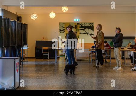 Vilnius, Lituania. 13 ottobre 2024. Le persone fanno la fila ai seggi elettorali per esprimere il proprio voto durante il primo turno di votazioni nelle elezioni parlamentari. La Lituania tiene il primo turno delle elezioni parlamentari per il Seimas. Credito: SOPA Images Limited/Alamy Live News Foto Stock