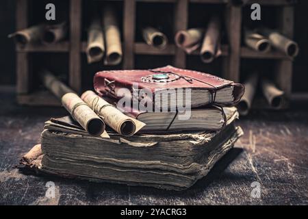 Vecchi libri e rotoli antichi in biblioteca su tavola di legno come sfondo mistico Foto Stock