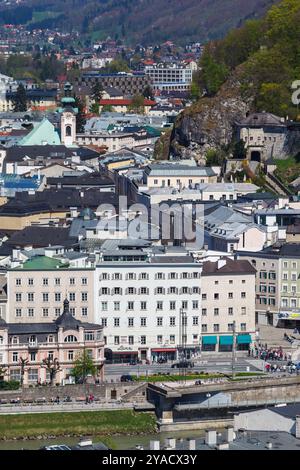 La Rektoratskirche St. Sebastian con la sua torre dell'orologio e gli edifici sul lungomare sulla riva del fiume Salzach nel centro di Salisburgo, Austria Foto Stock