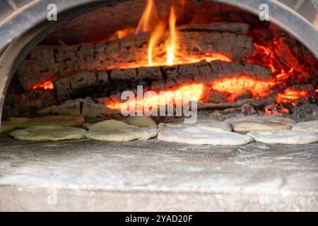 Cottura di pita in forno a legna sul mercato locale Foto Stock