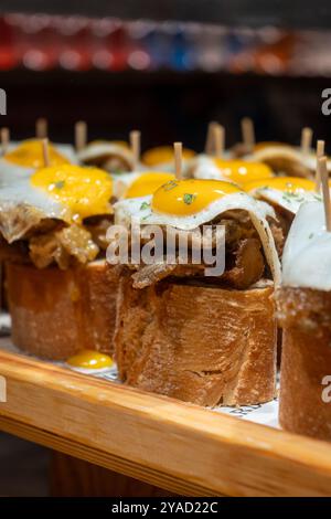 Spuntini tipici dei Paesi Baschi, spiedini di pinchos o pinxtos con piccoli pezzi di pane, pesce, frutti di mare, uova fritte serviti al bar di San Sebastian o. Foto Stock