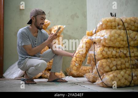 Un uomo lavora attivamente con Bags of Products in un ambiente di magazzino Foto Stock